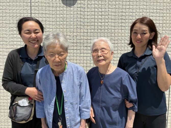 入居者と職員が笑顔で集合写真を撮っている場面