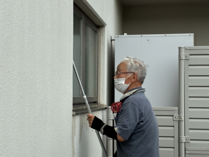 高齢者スタッフが窓の清掃・メンテナンス作業を行っている