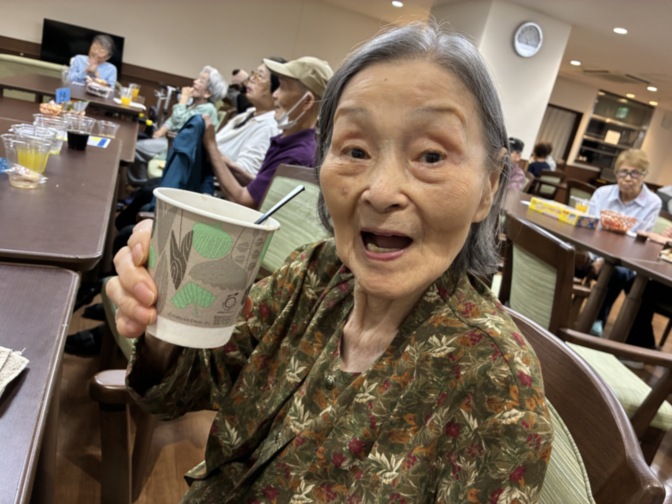 食堂で飲み物を持つ高齢女性の笑顔