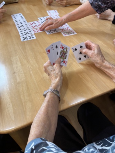 入居者がテーブルでカードゲームをしている様子。レクリエーション活動。