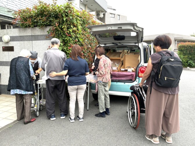 介護施設の入居者と職員が車を使用した移動・外出活動を行っている様子