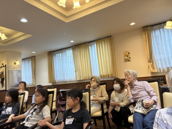 居室で複数の入居者が集まり、リラックスして過ごす風景。明るく清潔な共用スペース。
