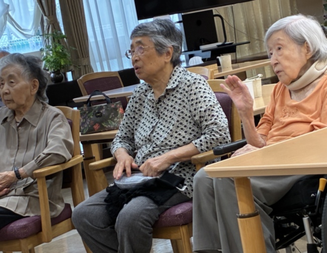 高齢入居者3名がリビングで会話・交流している様子
