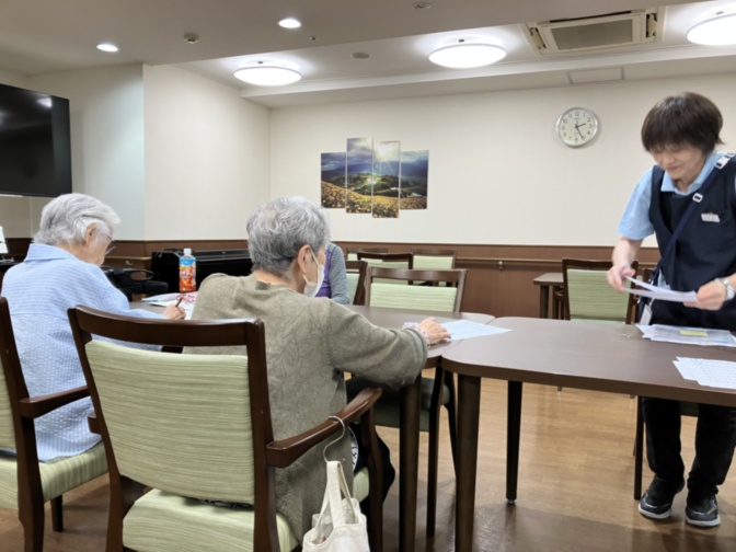 介護施設の共有スペースで職員が入居者と交流している風景