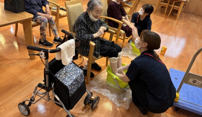 介護職員と高齢者による手工芸活動。共用スペースでの生活風景。