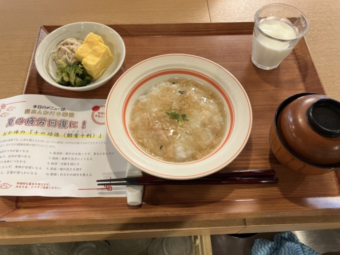 介護施設の食事風景。粥とおかず、牛乳が提供されている。