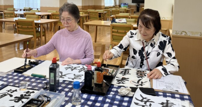 入居者が食堂でカリグラフィーやアート活動に取り組んでいる様子