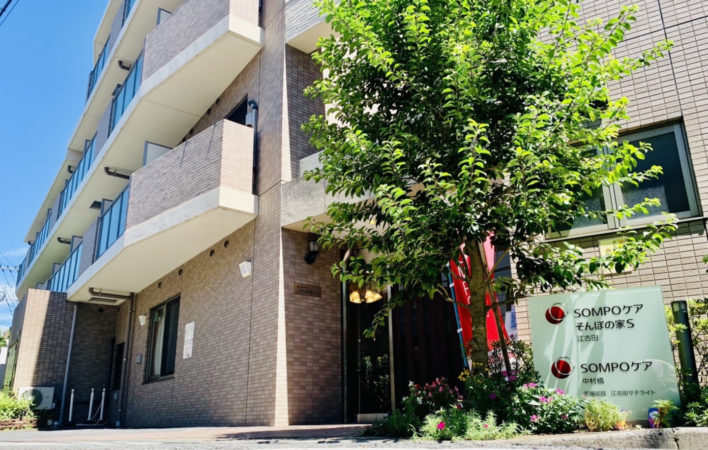 SOMPOケア施設の建物外観。レンガ造りモダン建築で、入口周辺に緑化が施されている。